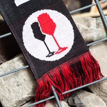 Lade das Bild in den Galerie-Viewer, Das Bild zeigt eine Nahaufnahme eines Schals. Er ist schwarz und hat schwarze und rote Fransen. Es ist ein Kreislogo darauf mit weißem Hintergrund und einem schwarzen und einem roten Weinglas. In Anlehnung an das klassische Antifa Logo.