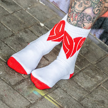 Lade das Bild in den Galerie-Viewer, Auf dem Foto sieht man die Füße und Unterschenkel eines Models. Die Beine sind tätowiert und die Socken sind weiß mit roten Fersen und Zehenbereich sowie einem großen roten Herz mittig vorne eingestickt. Das Model steht überkreuzt auf einem Steinfußboden.