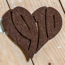 Lade das Bild in den Galerie-Viewer, Auf dem Foto sieht man einen Holzfußboden. Auf diesem befindet sich ein brauner Filzuntersetzer. Dieser ist herzförmig ausgestanzt und die Zahl 1910 zu erkennen.