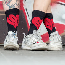 Lade das Bild in den Galerie-Viewer, Auf dem Foto sieht man 3 Beine von Models. Diese tragen jeweils schwarze Socken mit einem großen, roten 1910 Herz eingestickt. Sie tragen weiße Turnschuhe.