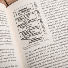 Lade das Bild in den Galerie-Viewer, Auf dem Bild sieht man eine Nahaufnahme einer Seite eines aufgeschlagenen Buches.