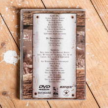 Lade das Bild in den Galerie-Viewer, Auf dem Bild sieht man einen Holzfußboden. Auf diesem liegt eine DVD. Mit der Rückseite nach oben. Es stehen viele verschiedene Songtitel darauf.