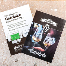 Lade das Bild in den Galerie-Viewer, Auf dem Bild sieht man einen Holzfußboden. Auf diesem liegen 2 Gutscheine für die 1910 Weinbar. Auf dem rechten Gutschein sieht man die Vorderseite. Es sind 2 Weingläser abgebildet auf denen der Schriftzug Kein Wein den Faschisten zu sehen ist. Auf dem linken sieht man die Rückseite auf der steht Einzulösen für Getränke im Wert von 15€. Desweiteren sieht man einen Lageplan des Millerntor Stadions.