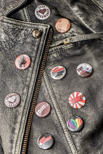 Lade das Bild in den Galerie-Viewer, Auf dem Bild erkennt man eine schwarze Lederjacke mit 10 verschiedenen Buttons darauf. Alles rund um 1910 eV Kiezbeben FC St.Pauli und Co.
